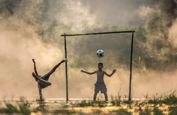 Free Amazing Sports Backgrounds for Designers: Kids Playing Football in Rain
