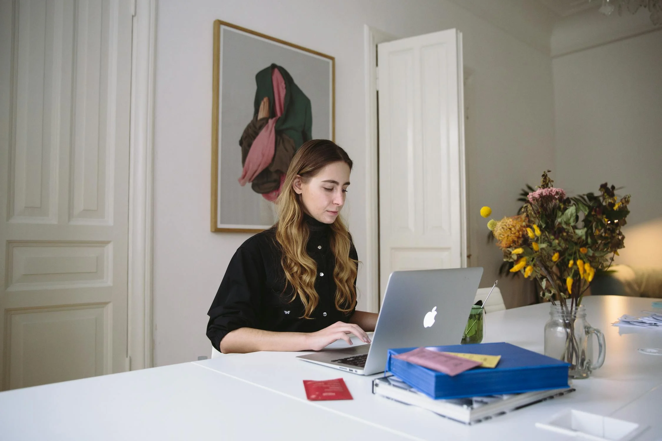 A woman working on a MacBook in a minimalistic workspace, illustrating how compressing images helps to Optimize Images for Web without losing quality.